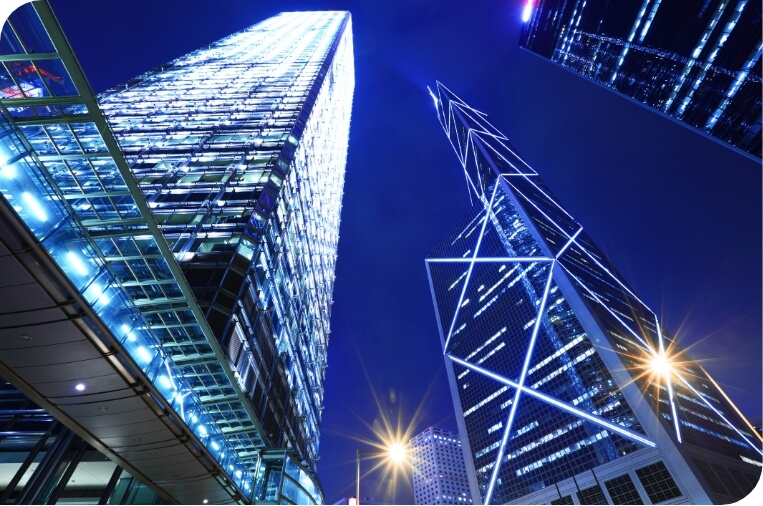 A night view of a city skyline featuring towering skyscrapers with intricate lighting patterns.